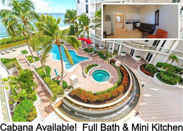 view of swimming pool featuring an in ground hot tub, a water view, and a patio