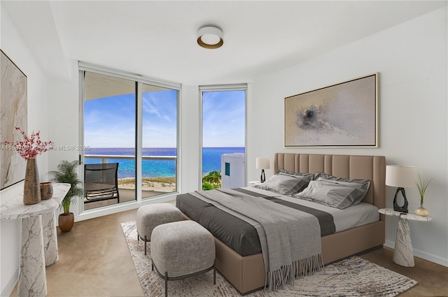 bedroom featuring expansive windows, a water view, and access to exterior