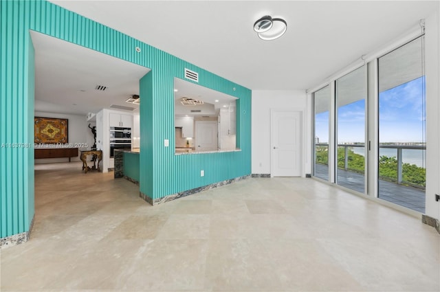 interior space with a water view and a wall of windows