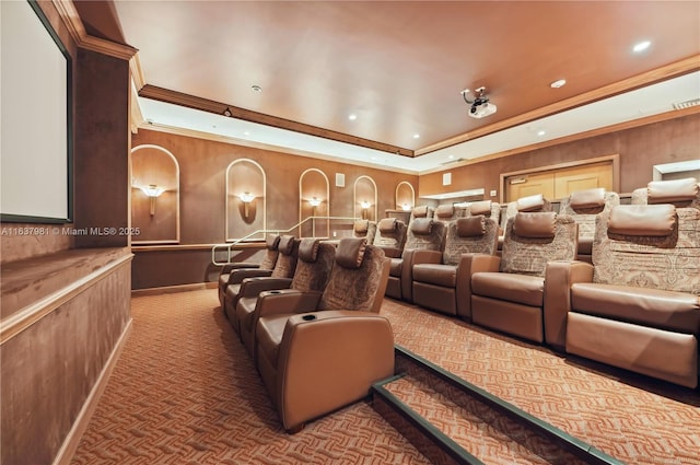 carpeted cinema room featuring ornamental molding and a raised ceiling