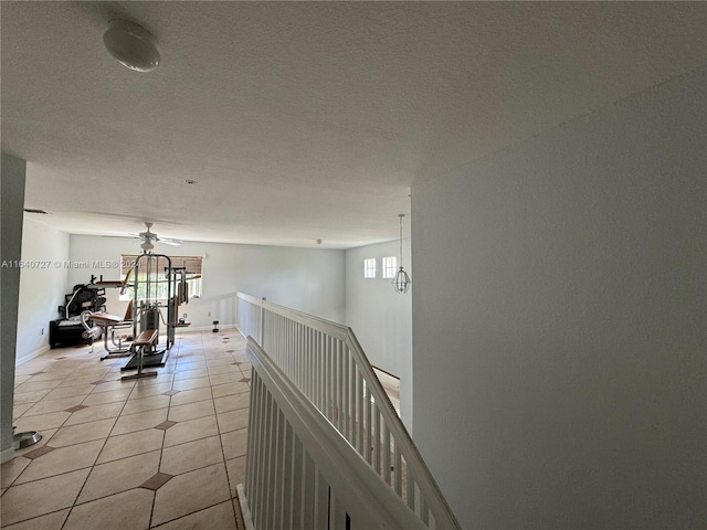 hallway with light tile patterned flooring and a textured ceiling