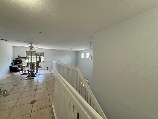 hallway featuring light tile patterned floors and a textured ceiling