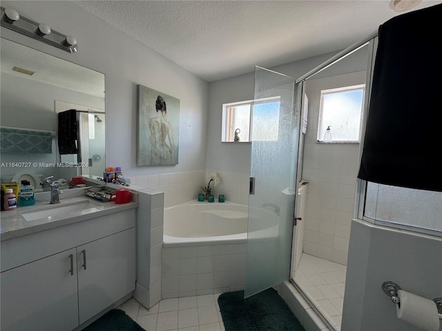 bathroom with tile patterned floors, vanity, a textured ceiling, and plus walk in shower