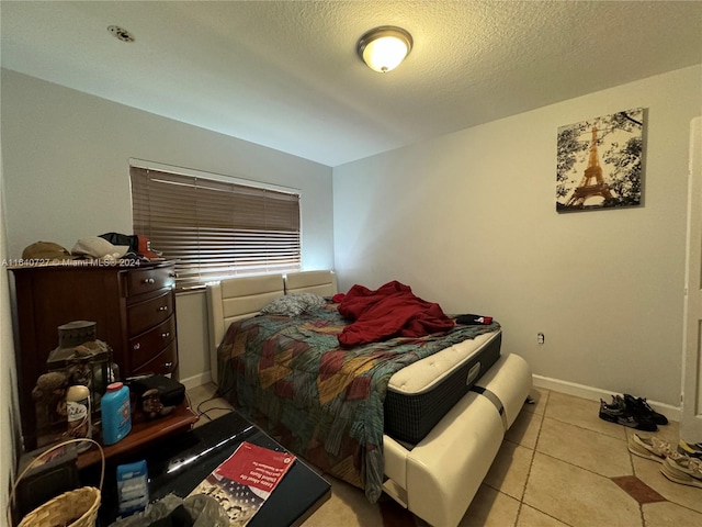 bedroom featuring light tile patterned flooring and a textured ceiling