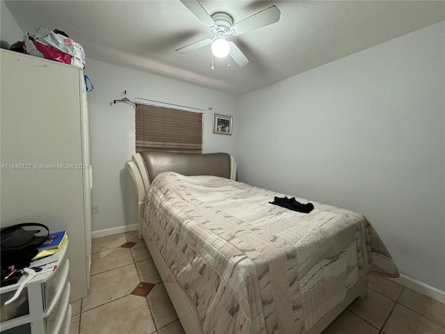 tiled bedroom featuring ceiling fan