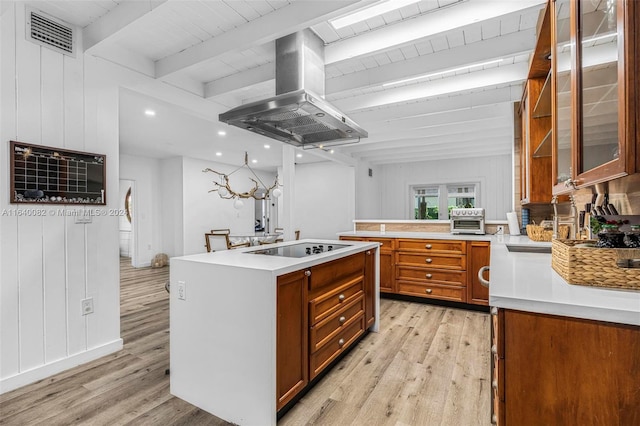 kitchen with island exhaust hood, beam ceiling, black electric stovetop, and light hardwood / wood-style floors