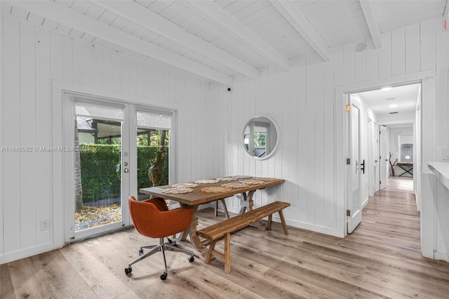 dining area featuring wooden walls, light wood-type flooring, and french doors