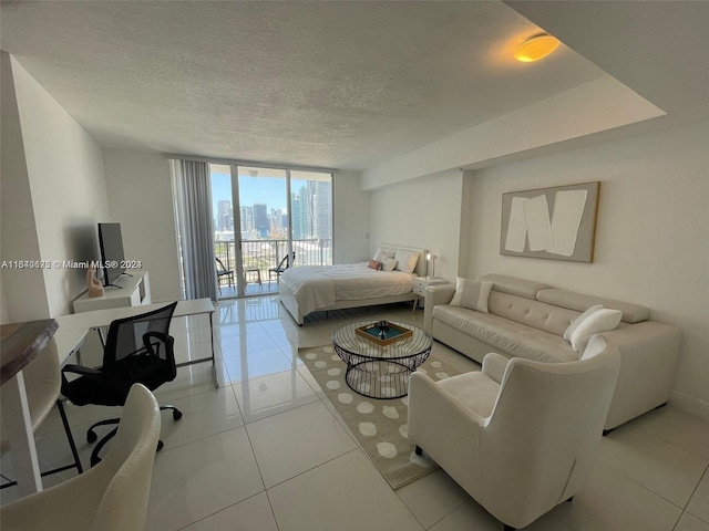 bedroom featuring access to exterior, tile patterned flooring, floor to ceiling windows, and a textured ceiling