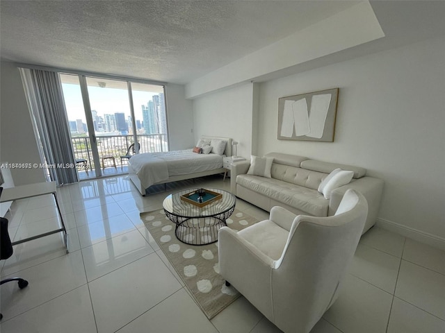 tiled bedroom with a view of city, a textured ceiling, floor to ceiling windows, baseboards, and access to exterior