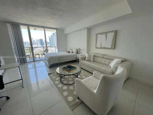 1750 N Bayshore Dr Unit 2708, Miami, FL 33132 - tiled bedroom with a wall of windows, access to exterior, baseboards, a textured ceiling, and a city view