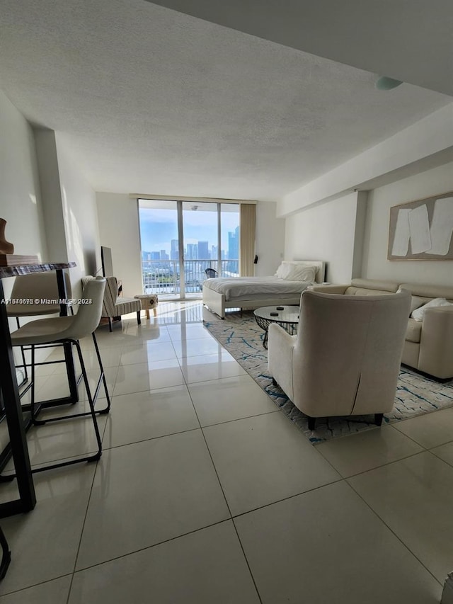 living area with light tile patterned floors, expansive windows, a textured ceiling, and a city view