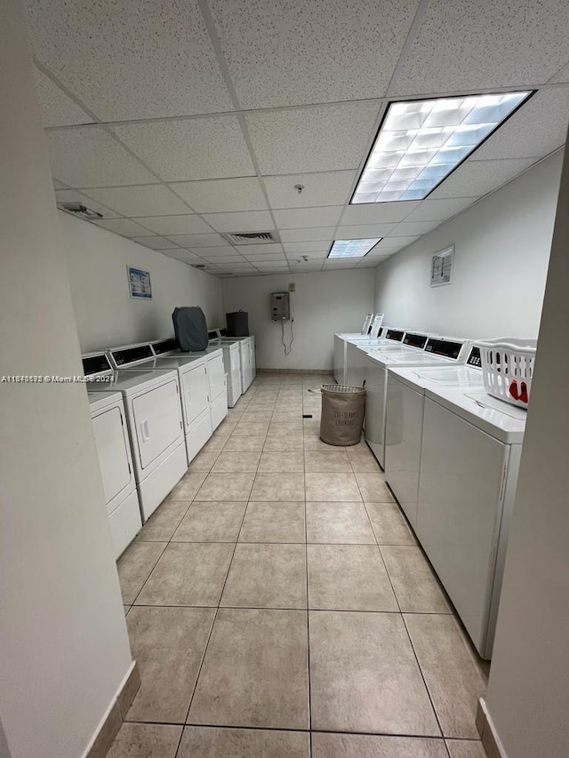 shared laundry area with light tile patterned flooring, visible vents, baseboards, and washing machine and clothes dryer