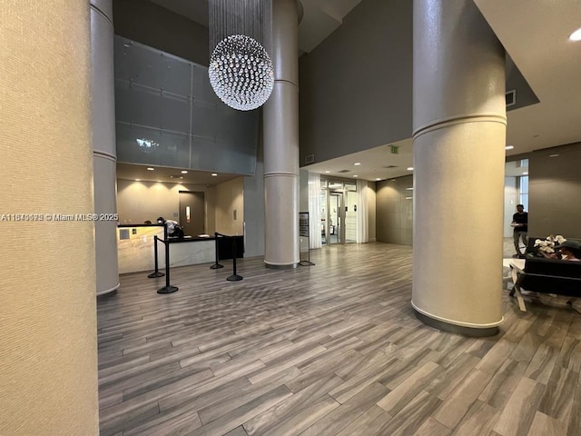 1750 N Bayshore Dr Unit 2708, Miami, FL 33132 - workout area with decorative columns, a towering ceiling, and wood finished floors