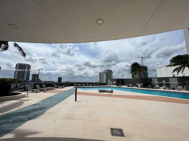 pool with a view of city and a patio area