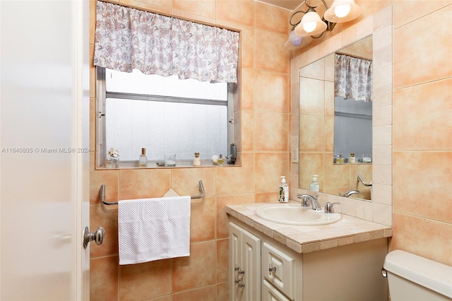 bathroom featuring tile walls, toilet, and vanity