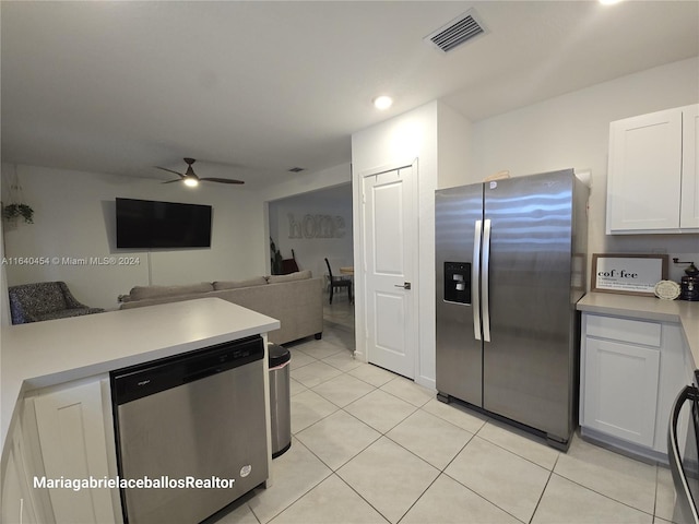 kitchen with appliances with stainless steel finishes, white cabinetry, light tile patterned floors, and ceiling fan