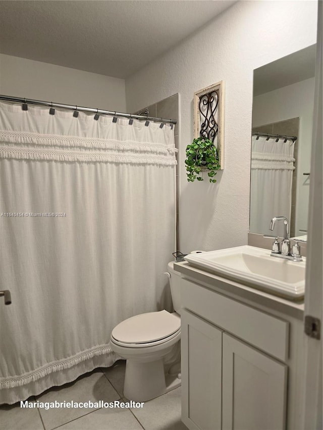 bathroom featuring tile patterned floors, vanity, and toilet