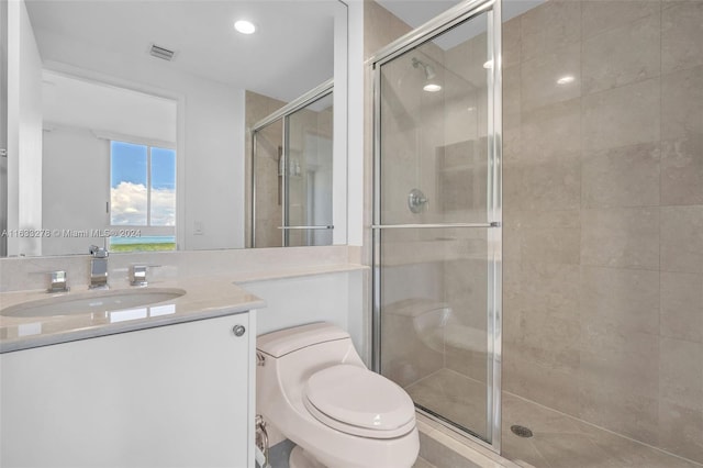 bathroom with an enclosed shower, vanity, and toilet