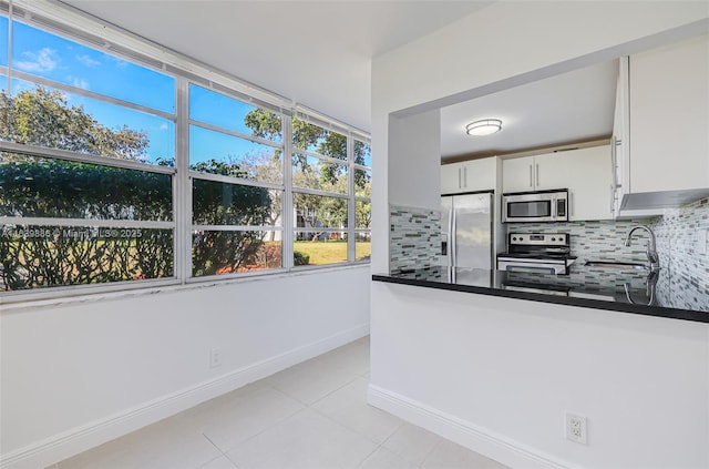 kitchen featuring stainless steel appliances, sink, decorative backsplash, and white cabinets