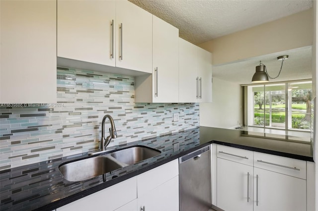 kitchen with a textured ceiling, decorative backsplash, sink, white cabinetry, and stainless steel dishwasher