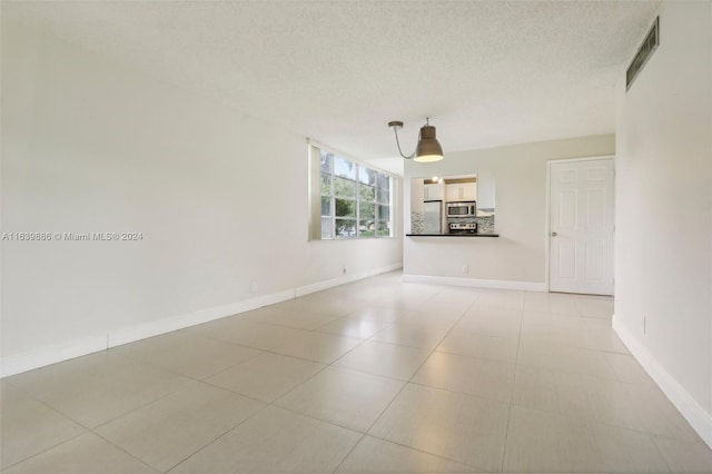 interior space with a textured ceiling and light tile patterned floors