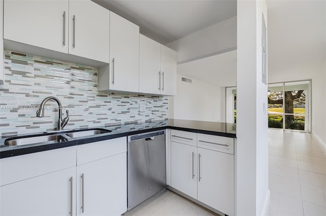 kitchen with sink, stainless steel dishwasher, white cabinets, and backsplash