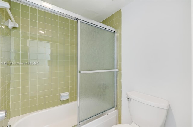 bathroom featuring shower / bath combination with glass door and toilet