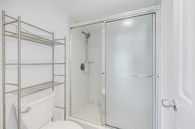 bathroom featuring walk in shower and toilet