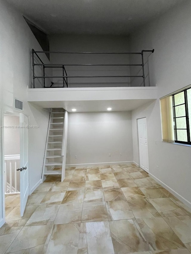 interior space with a towering ceiling and light tile patterned floors