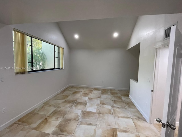 tiled empty room with vaulted ceiling