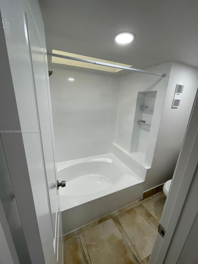 bathroom with tile patterned floors, shower / bath combination, and toilet