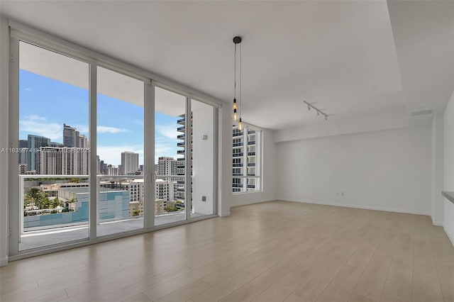 601 NE 27th St Unit 1206, Miami, FL 33137 - empty room with track lighting, wood finished floors, a skyline view, and baseboards