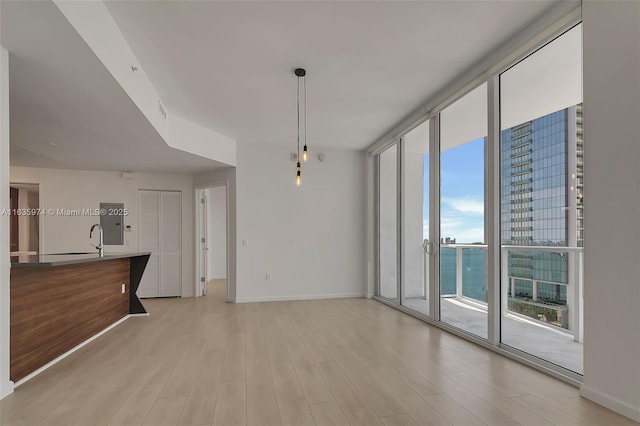 601 NE 27th St Unit 1206, Miami, FL 33137 - unfurnished dining area with a wall of windows, light wood-style flooring, and baseboards