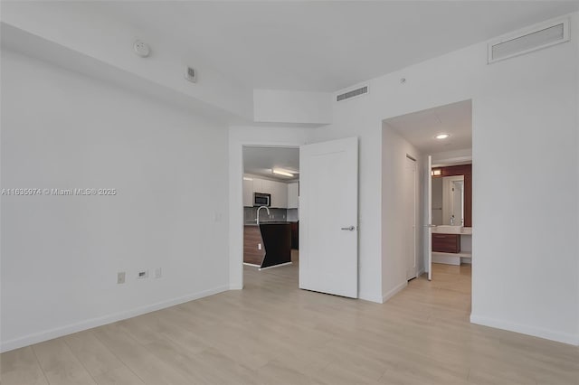 601 NE 27th St Unit 1206, Miami, FL 33137 - spare room featuring light wood-style floors, a smoke detector, and baseboards