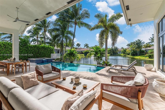 view of pool with ceiling fan, a patio, an outdoor hangout area, and a water view