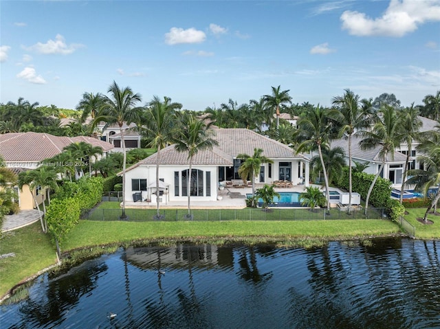 rear view of house featuring a lawn, a patio, and a water view