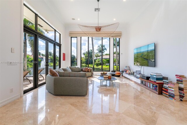 tiled living room featuring french doors and ornamental molding