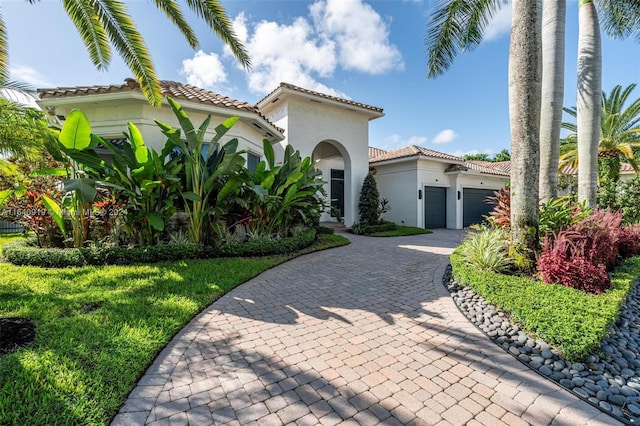 mediterranean / spanish-style home with a front lawn and a garage