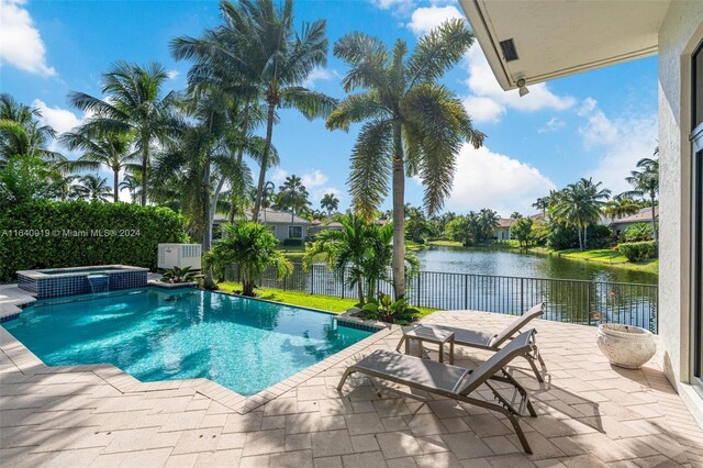 view of swimming pool featuring a water view, an in ground hot tub, and a patio area