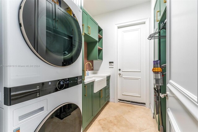 interior space featuring light tile patterned floors, stacked washer / drying machine, cabinets, and sink