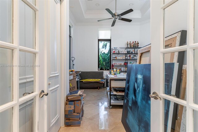 tiled home office with ceiling fan, french doors, and a tray ceiling