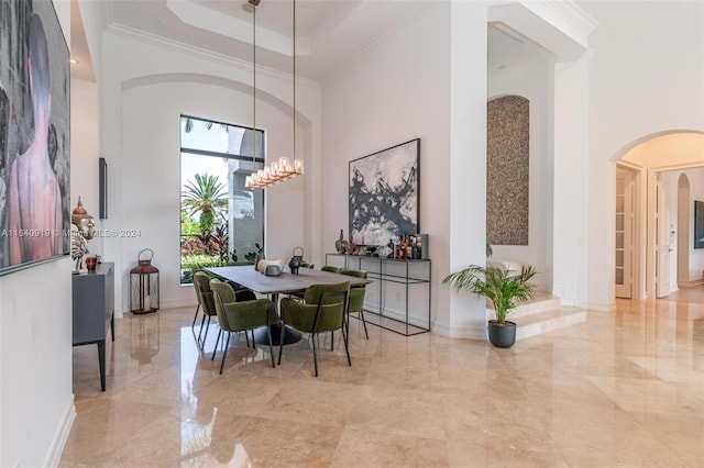 tiled dining room featuring a towering ceiling, a tray ceiling, and a chandelier