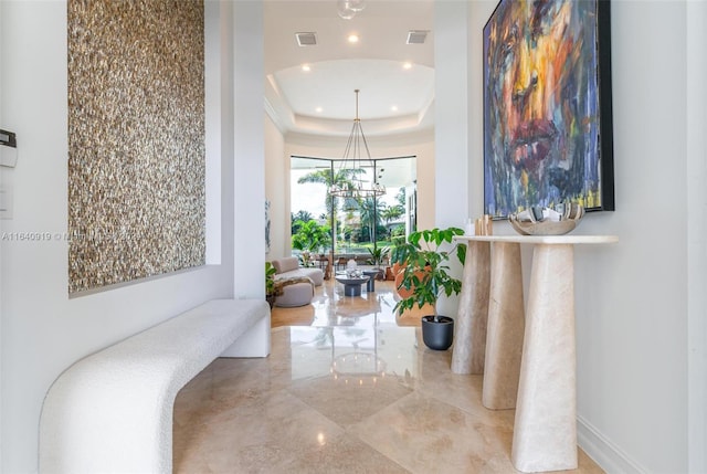 hall featuring light tile patterned flooring and a raised ceiling