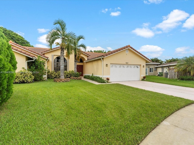 mediterranean / spanish home featuring a garage and a front yard