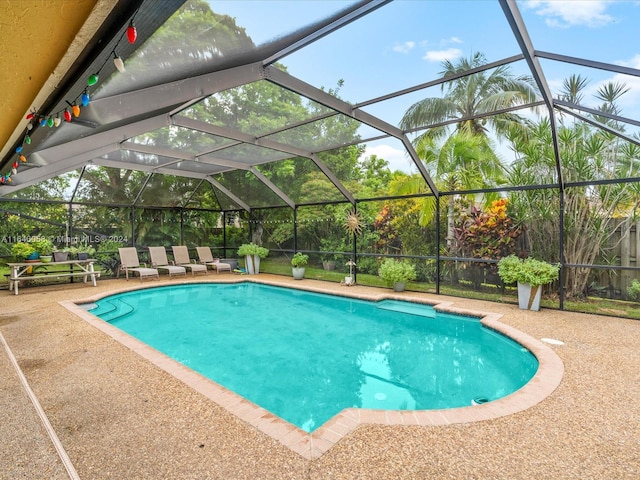 view of swimming pool featuring a lanai and a patio area