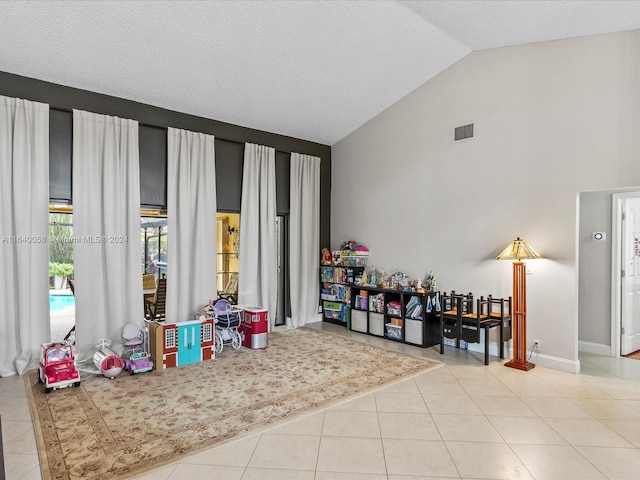 rec room featuring vaulted ceiling and light tile patterned flooring