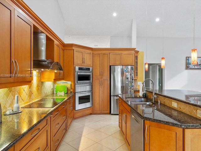 kitchen featuring decorative light fixtures, light tile patterned floors, stainless steel appliances, sink, and wall chimney range hood