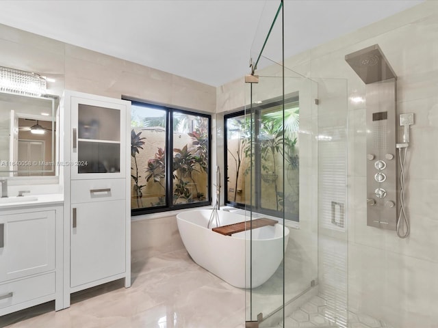 bathroom with plus walk in shower, tile walls, and vanity