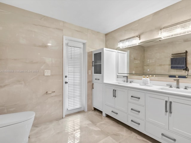 bathroom with vanity, toilet, and tile walls