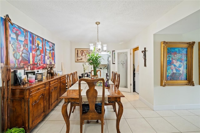 tiled dining area with a textured ceiling and an inviting chandelier